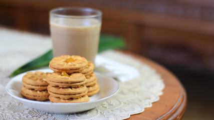 Breakfast and snack menu. Butter biscuits with pineapple jam and a glass of chocolate milk. Close-up of butter cookies and a glass of chocolate, sweet cakes. Perfect for recipes, articles, catalogs.