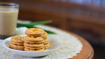 Breakfast and snack menu. Butter biscuits with pineapple jam and a glass of chocolate milk. Close-up of butter cookies and a glass of chocolate, sweet cakes. Perfect for recipes, articles, catalogs.