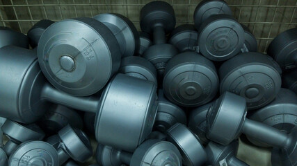 Pile of gray dumbbells stacked in storage area
