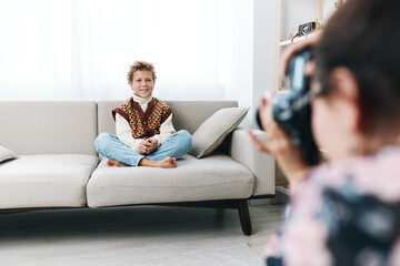 Obraz premium Authentic lifestyle photography capturing a child at home in a playful school themed moment, seated on a couch, relaxed pose, natural light, everyday learning vibe.