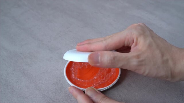 Opening Orange Dental Aligner Case that orthodontic mouthpiece storaged. Slow motion video.
