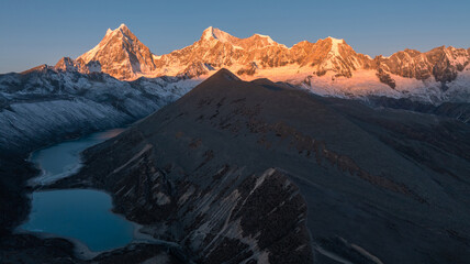 Aerial view of beautiful snow capped mountain and lake sunrise landscape in Tibet, China