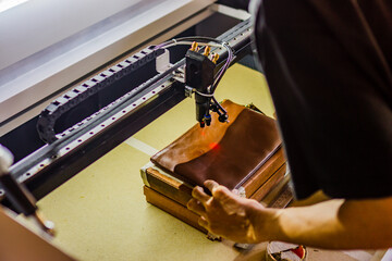 The process of making laser engraving on brown leather bags, perfect for leather industry company...