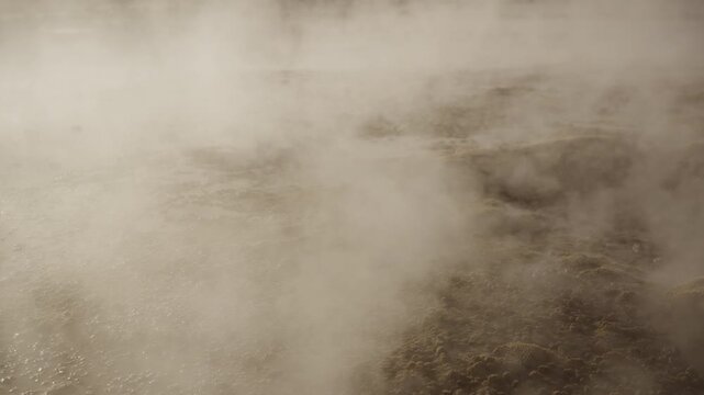 Close up shot of a steaming geyser at sunrise in El Tatio Geysers field in the Atacama Desert with volcanic terrain and dramatic light in the high Andean plateau of northern Chile