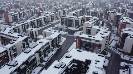 Urban landscape blanketed in snow during winter, showcasing modern architecture and quiet streets - Powered by Adobe
