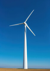 Wind Turbine in Blue Sky: A towering wind turbine stands tall against a vibrant azure sky, its blades gracefully rotating in the wind, showcasing renewable energy.
