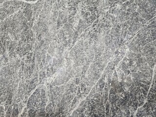 Textured grey marble surface with intricate natural veining, a sophisticated backdrop for design