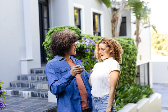 Young diverse couple laughing and enjoying conversation outdoors in garden setting