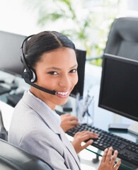 In office, businesswoman using headset and computer, providing customer support