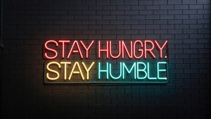 Fototapeta premium Neon Sign with Inspirational Quote About Ambition and Humility in Urban Setting