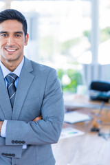 Obraz premium Smiling businessman in suit standing confidently in modern office environment, copy space