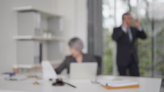 Blurred image professional lawyers diligently working in modern legal office providing legal advice at a busy law firm