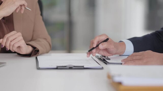 Legal professionals business clients review important documents discuss contract agreement formal consultation office meeting