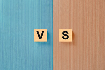 Letters VS on wooden background with copy space. The concept of making choice. Versus letters....