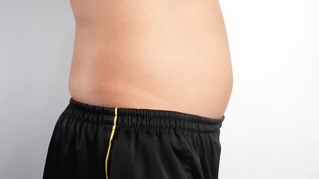 a man shrinking and expanding his belly with breath from a side view