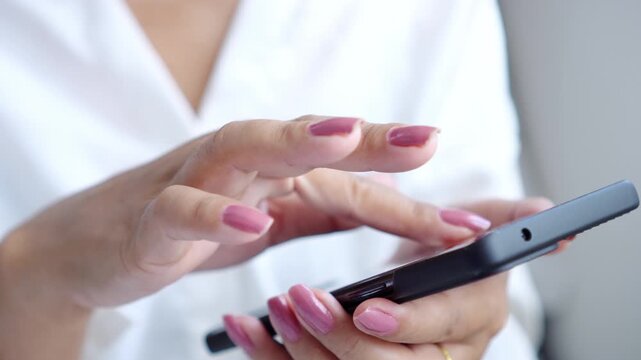 woman hand using a smartphone for texting, browsing social media, and managing digital work. Modern connectivity and mobile technology in everyday life, showing online communication, productivity