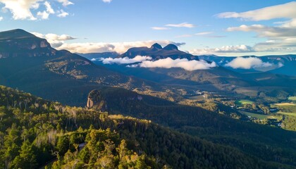 Majestic mountain range with clouds and forest.