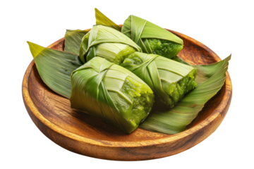 Pandanus fruit wraps or asian rice cakes wrapped in green banana leaves placed on wooden plate, isolated on white transparent background, concept of traditional cuisine