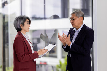 Asian adult lawyer woman consults older businessman client professional legal brief discussion...