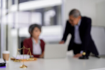 Asian Adult Lawyers Consulting on Justice Case Utilizing Laptop Computer in Professional Law Office Setting