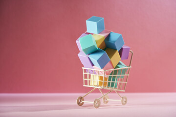 Colorful cube block in Cart on a pink background.