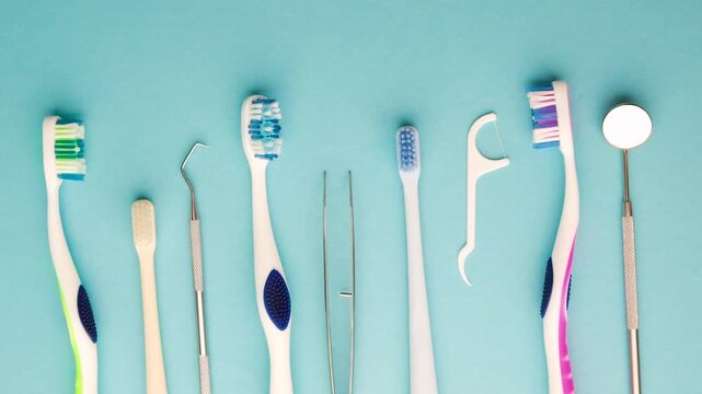 Oral hygiene tools including toothbrushes dental picks floss and mirror on blue background