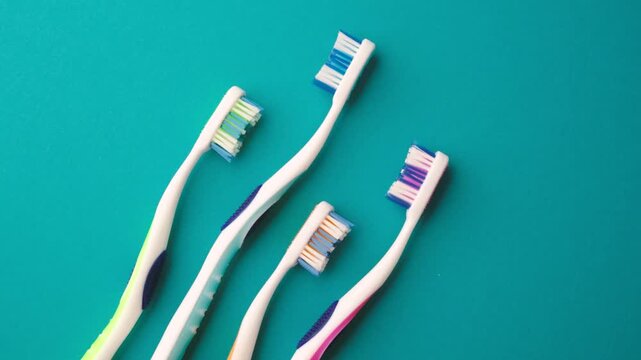 Four colorful toothbrushes arranged in a pattern on a blue background.