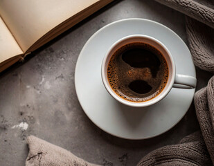 Top view of a cup of black coffee on the rustic stone table with a part of a book.