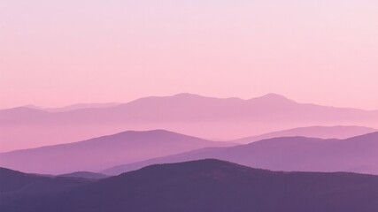 Obraz premium Layered mountain ranges under a soft pink and purple twilight sky