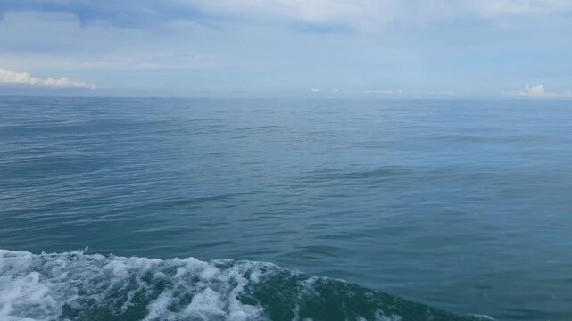 Beautiful ocean view from a boat in Pariaman, Indonesia, with foamy waves and a cloudy sky on the sea