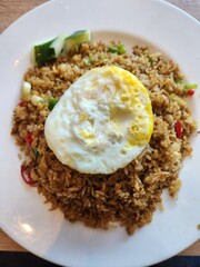 Indonesian fried rice, or Nasi Goreng, is a flavorful stir-fried rice dish cooked with sweet soy sauce, spices, and toppings like egg, chicken, or shrimp