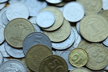 Metal coins of Ukraine of different denominations are scattered. Money texture, business background.