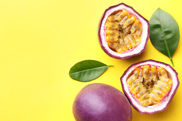 Fresh passion fruits with green leaves on yellow background, flat lay. Space for text