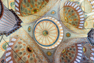 Naklejka premium Blue Mosque Ceiling View With Multiple Domes And Islamic Geometric Patterns In Istanbul Turkey. Sultanahmet Camii interior, ornate Ottoman design