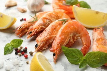 Tasty grilled shrimps and products on white marble table, closeup. Delicious seafood dish