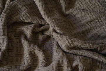 a knitted blanket lies comfortably on the sofa