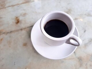 Cup of coffee on marble dinning table.