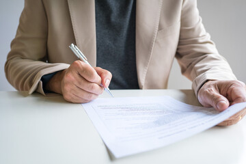 Businessman holding a pen, to complete a survey or signing a document.