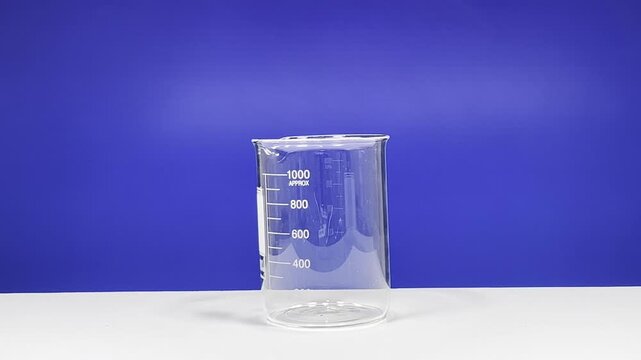 Empty laboratory beaker against blue background