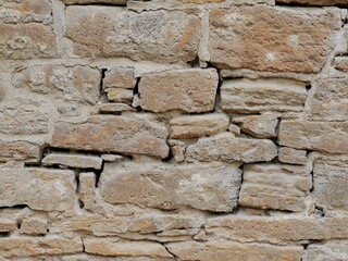 Rustic natural stone wall with irregular fieldstones, mortar and rough surface. Copyspace.