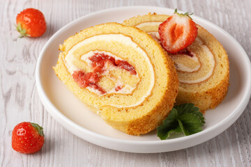 Two pieces of strawberry roll on a white plate