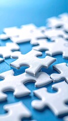 Close-up of many white jigsaw puzzle pieces on a blue surface