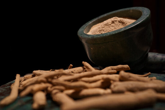 Ashwagandha herbal powder with raw ashwagandha roots near