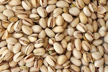 Tasty unpeeled pistachios as background, top view flat lay background