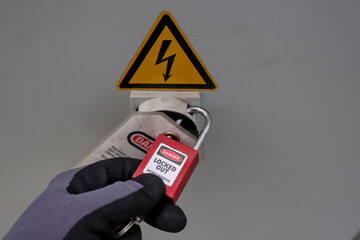 Lockout, tagout of equipment or electrical cabinet. Safety procedure protecting workers. Preventing...