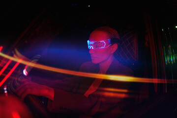 Woman in Futuristic High-tech VR Eyewear driving car in night ci