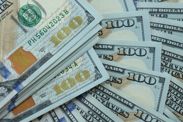 Many hundred dollar bills new banknotes in big pile under the natural light