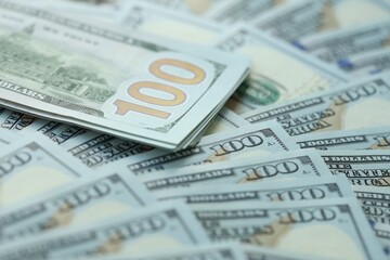 Many hundred dollar bills new banknotes in big pile under the natural light