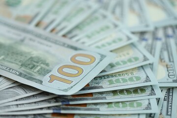 Many hundred dollar bills new banknotes in big pile under the natural light