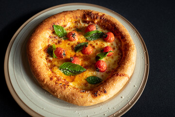 Pizza Delight: A delicious, freshly baked pizza on a rustic plate, adorned with vibrant cherry tomatoes and fragrant basil leaves, ready to be savored.